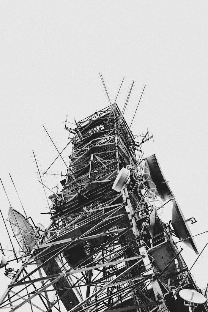 A monochromatic view of a towering radio communications structure capturing various antennas.